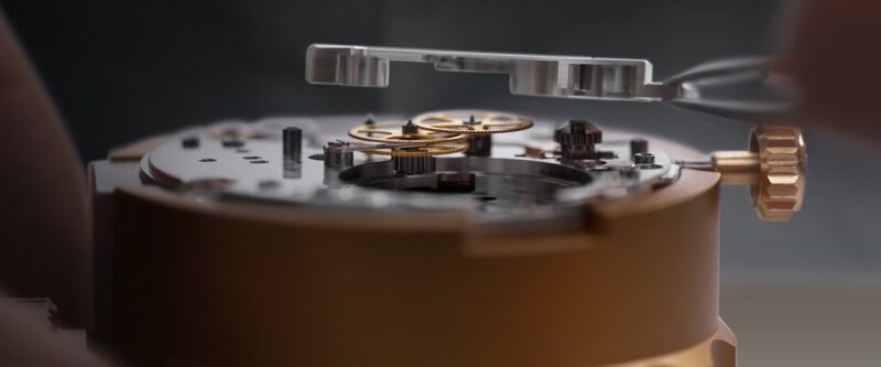 Watch movement and tool in a holder in Rolex service photography