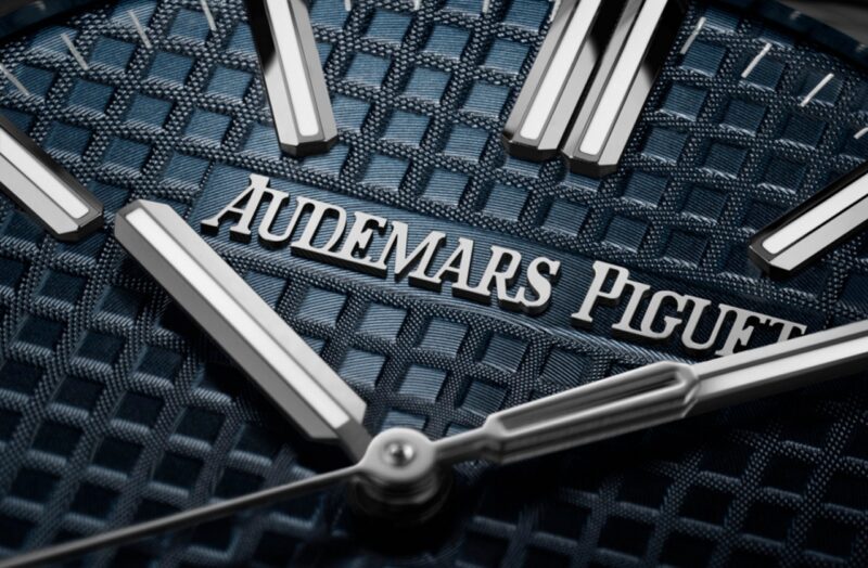 Close photographic view of the Royal Oak blue dial texture, hands and Audemars Piguet signature
