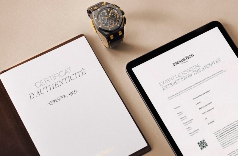 Audemars Piguet watch beside an authenticity certificate and archive extract