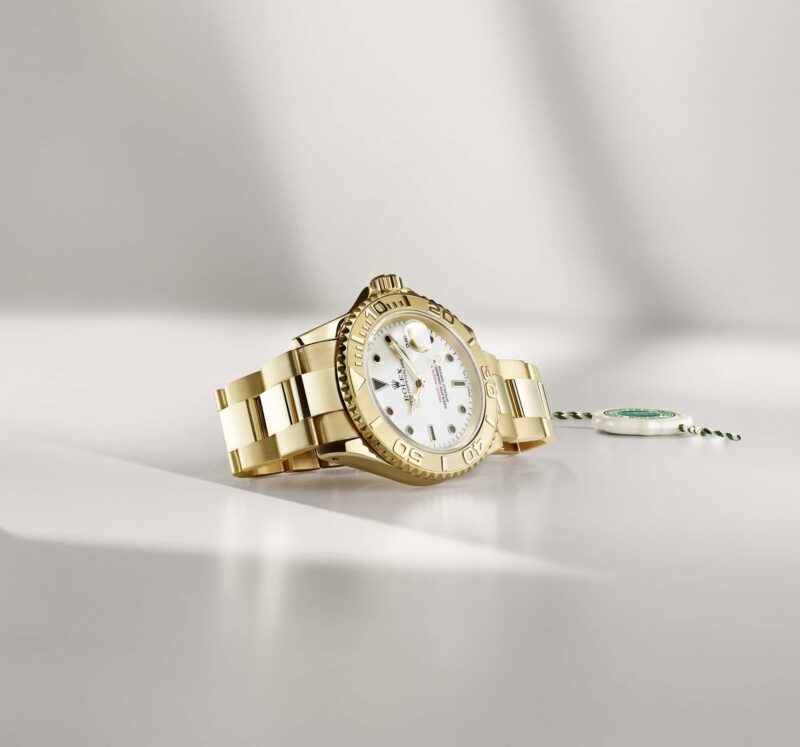 Gold Rolex Yacht-Master photographed beside its Certified Pre-Owned seal