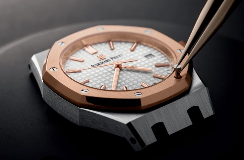 Close view of an Audemars Piguet watch dial and case beside a tool