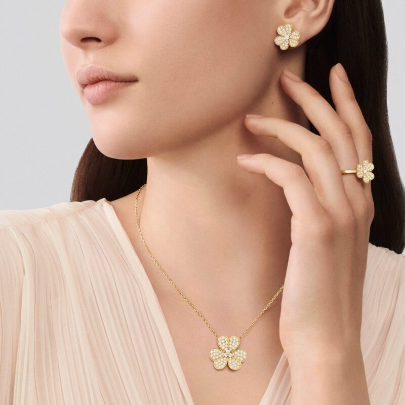 Van Cleef & Arpels floral pendant, earrings and ring worn with a pale blouse