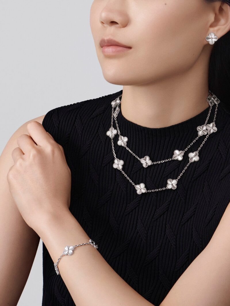 Van Cleef & Arpels diamond necklaces, earrings and bracelet worn with a black top
