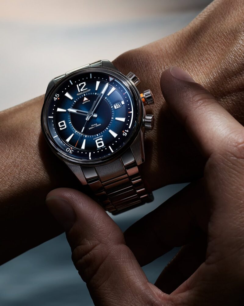 Hand operating the crown of a Jaeger-LeCoultre watch on the wrist
