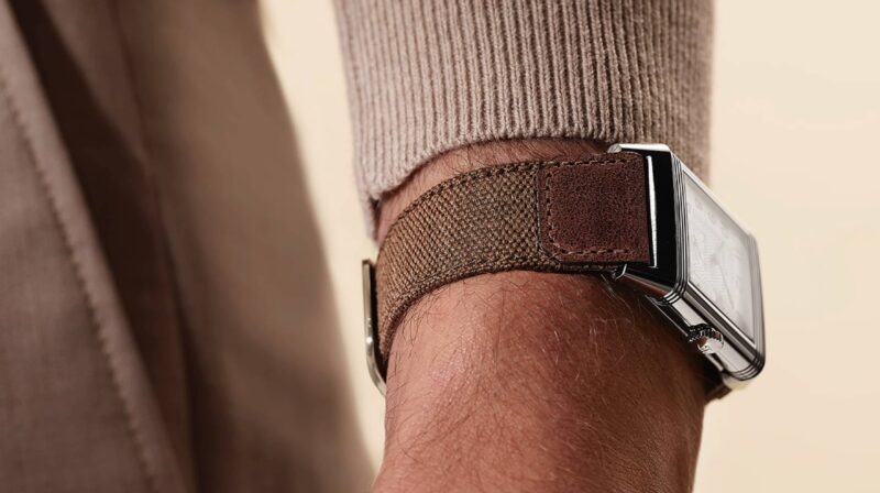 Jaeger-LeCoultre Reverso on a fabric strap beneath a knitted cuff