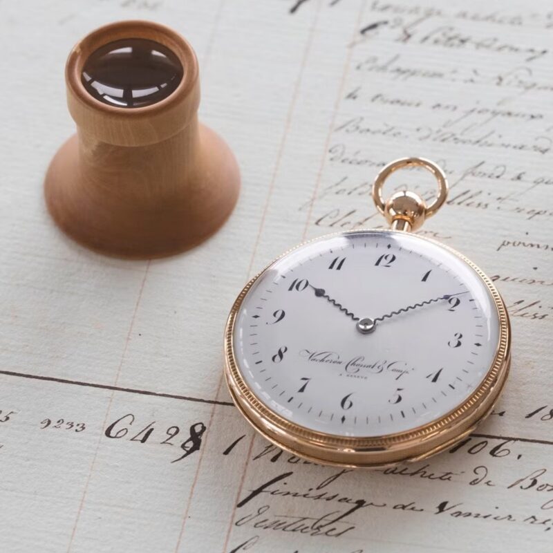 Gold Vacheron Constantin pocket watch lying on handwritten archive documents