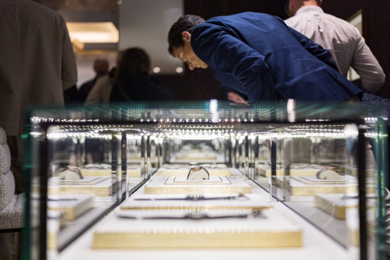Visitors examining watches in glass display cases in Watches and Wonders official city-programme photography