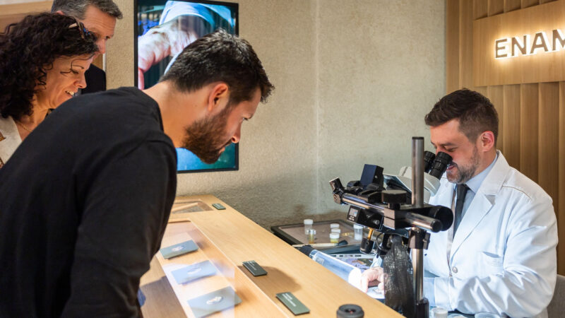 Visitors watching a craftsman at a microscope and workbench in official Watches and Wonders photography