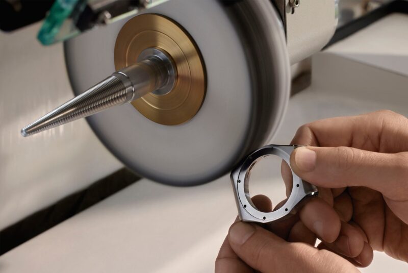 An Audemars Piguet watch case being refinished at a polishing wheel