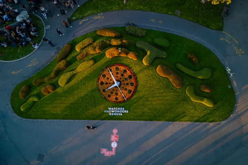 A floral clock and Watches and Wonders Geneva lettering viewed from above in the city programme