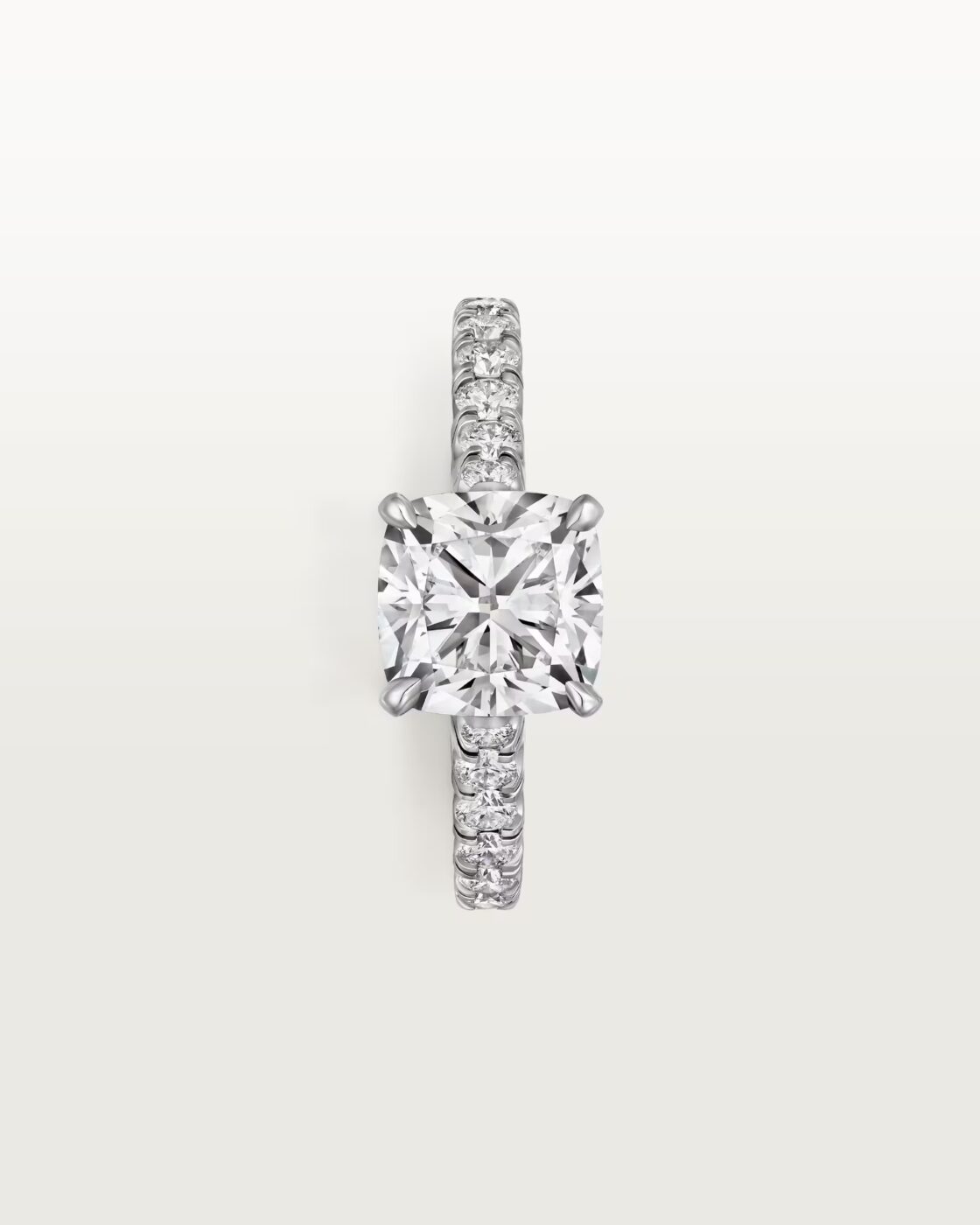 Close-up lifestyle view of a model wearing a classic Cartier Trinity ring while holding a white flower