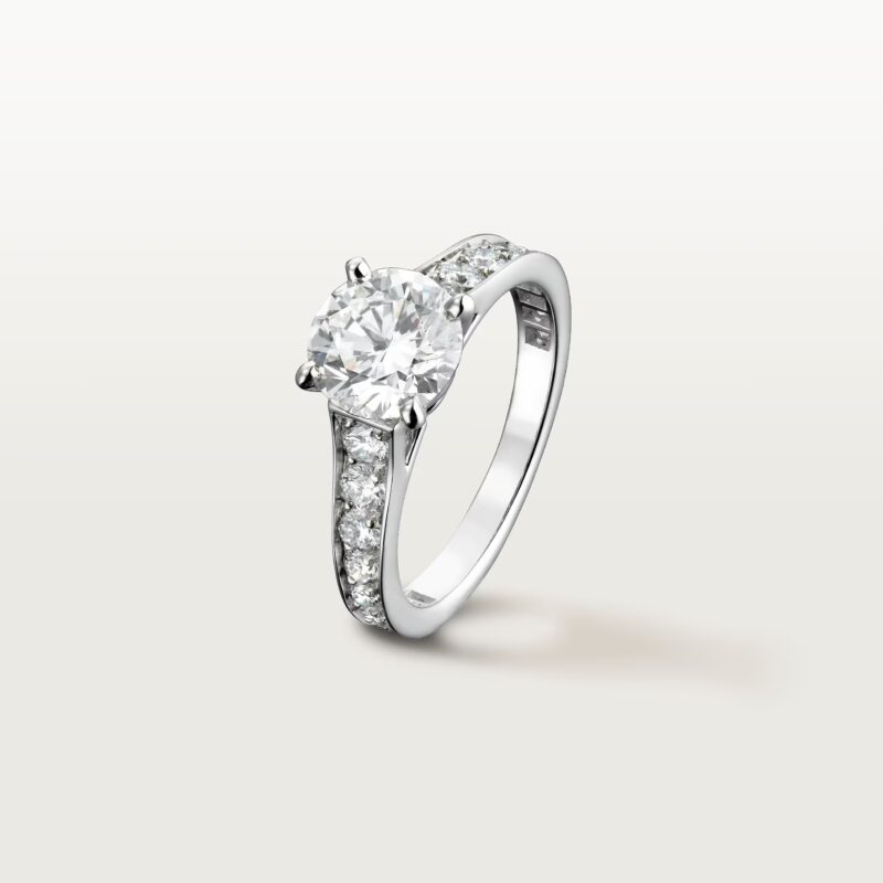 A studio shot of the Cartier Trinity ring variant with one band set with pave diamonds and two plain bands