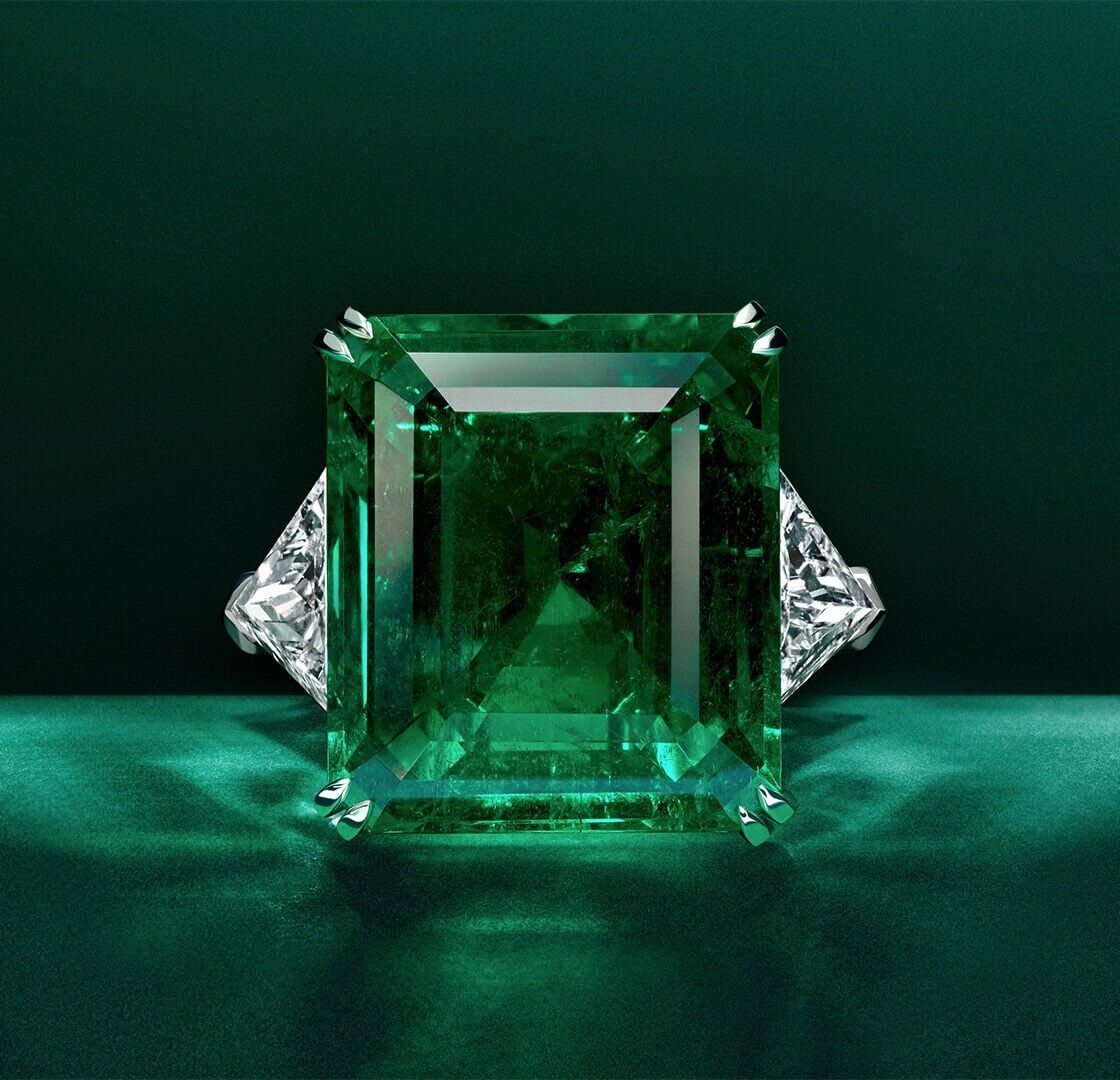 Graff emerald and white diamond high jewellery bangle on green background
