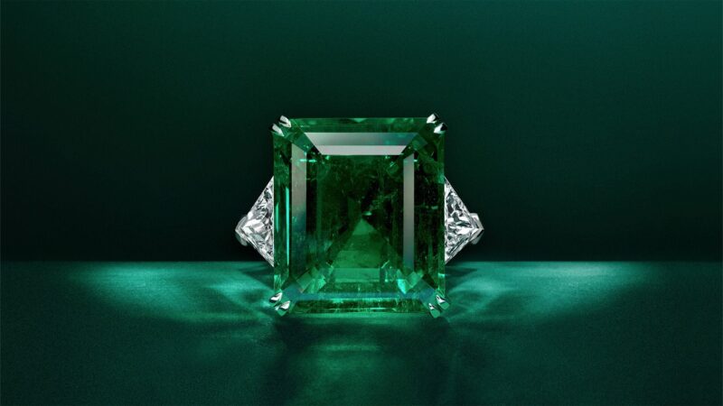 Graff emerald and white diamond high jewellery bangle on green background