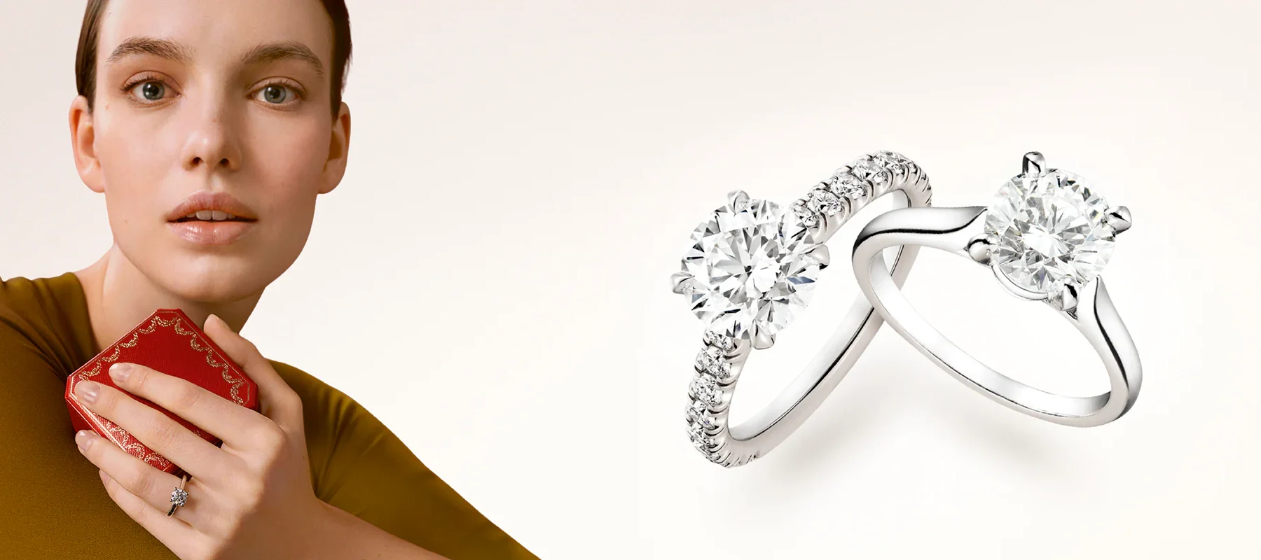 The Cartier Solitaire 1895 engagement ring resting on a white surface next to an open signature red Cartier ring box