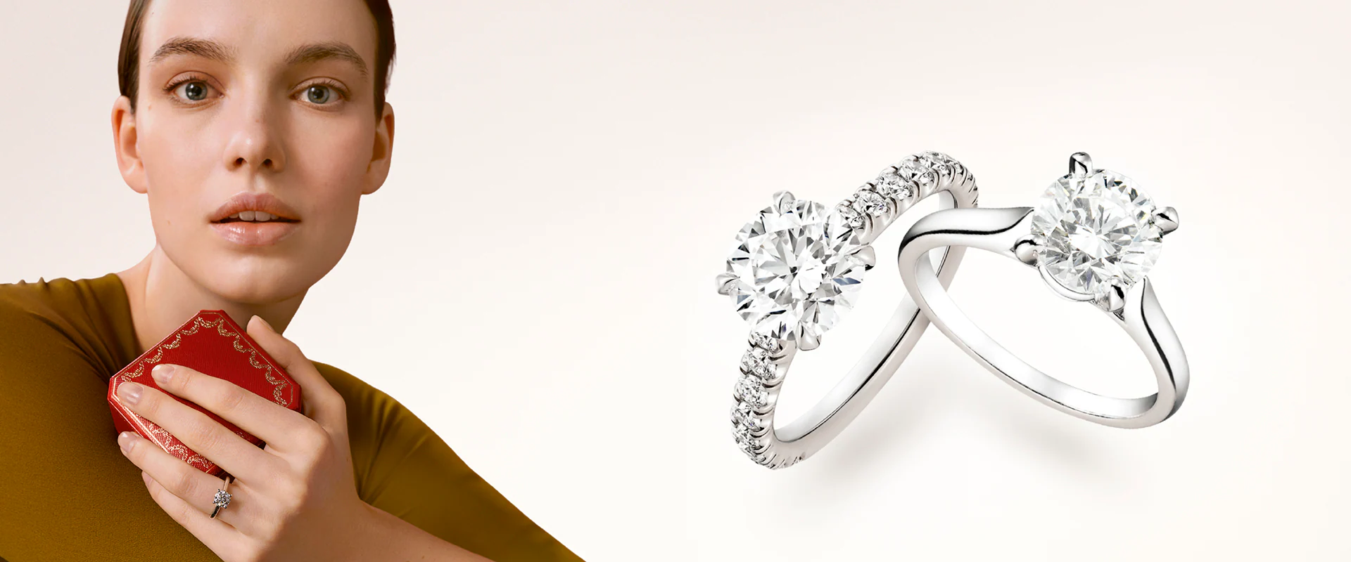 The Cartier Solitaire 1895 engagement ring resting on a white surface next to an open signature red Cartier ring box
