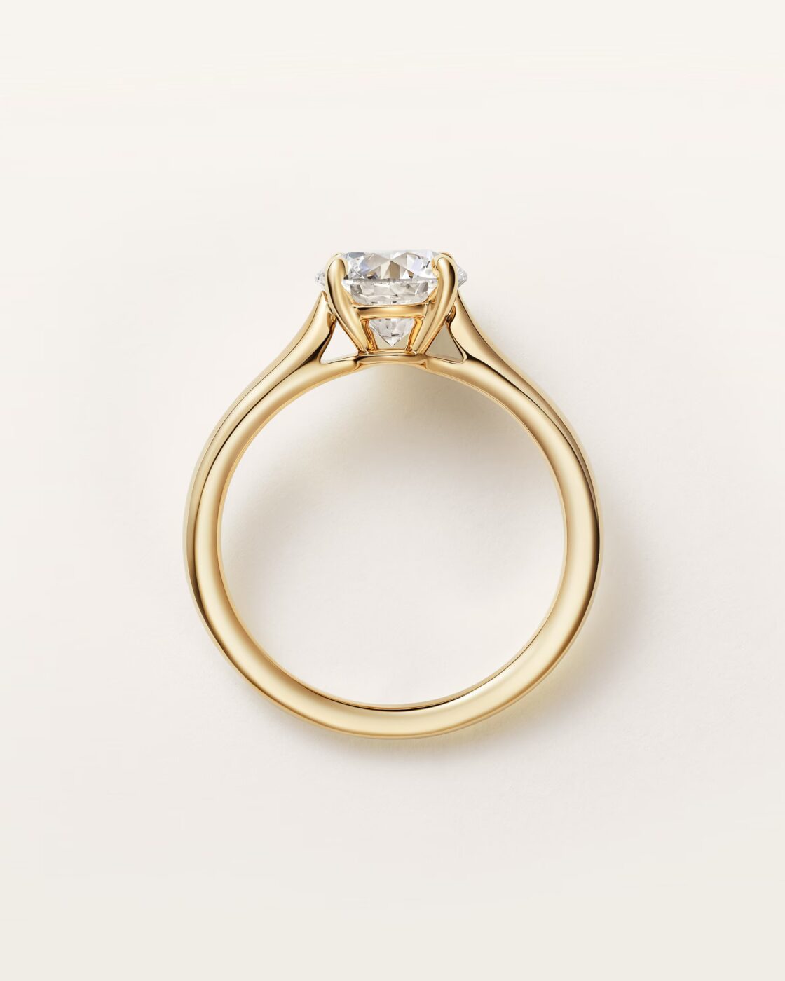 Side-profile studio view of the Cartier Solitaire 1895 ring with a pave-set diamond band
