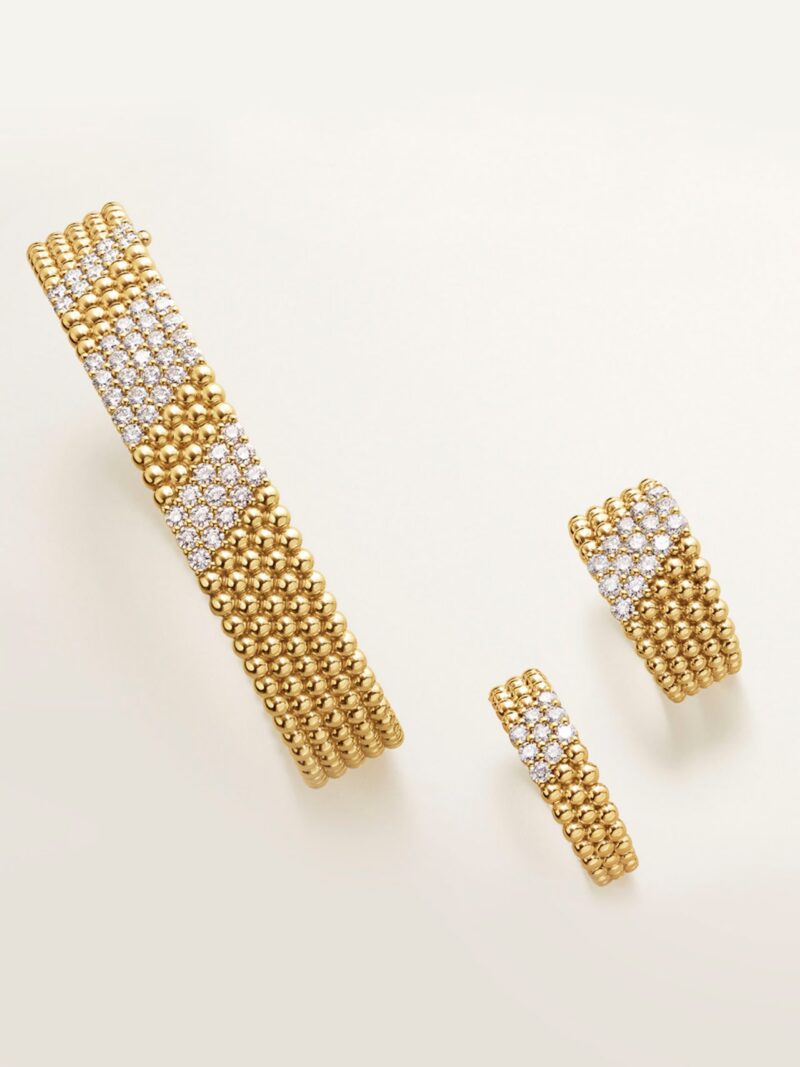 Flat-lay photo of a wide yellow gold Perlée bracelet paved with diamonds and two matching Perlée diamond rings