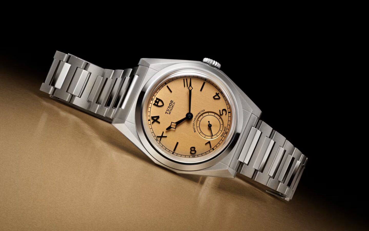 Faceted Tudor Monarch watch on gold surface, centenary edition