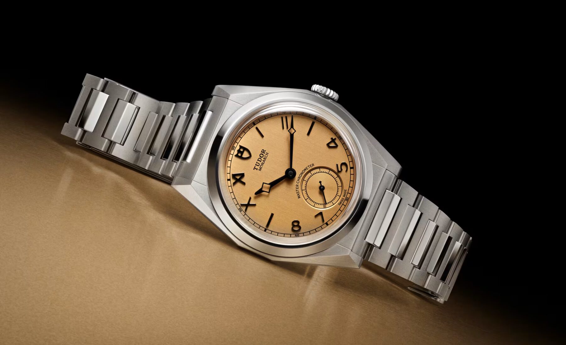 Faceted Tudor Monarch watch on gold surface, centenary edition