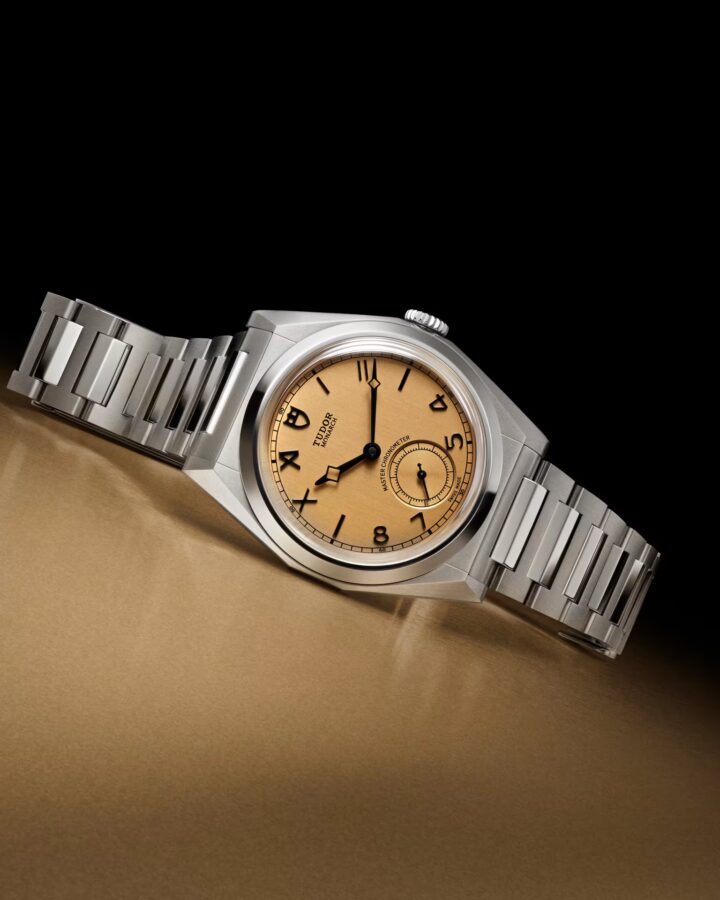 Faceted Tudor Monarch watch on gold surface, centenary edition