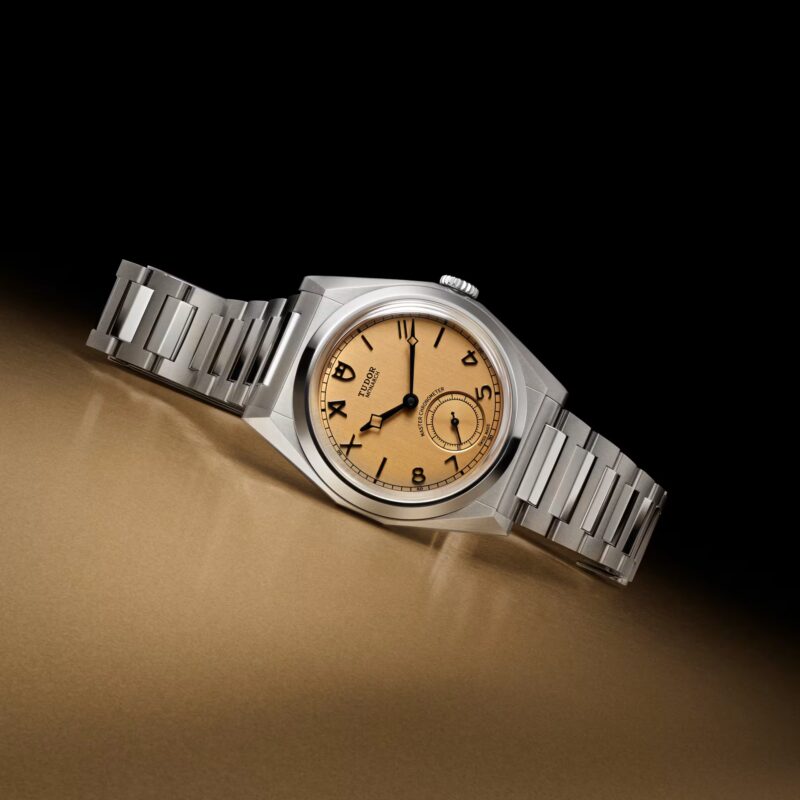 Faceted Tudor Monarch watch on gold surface, centenary edition