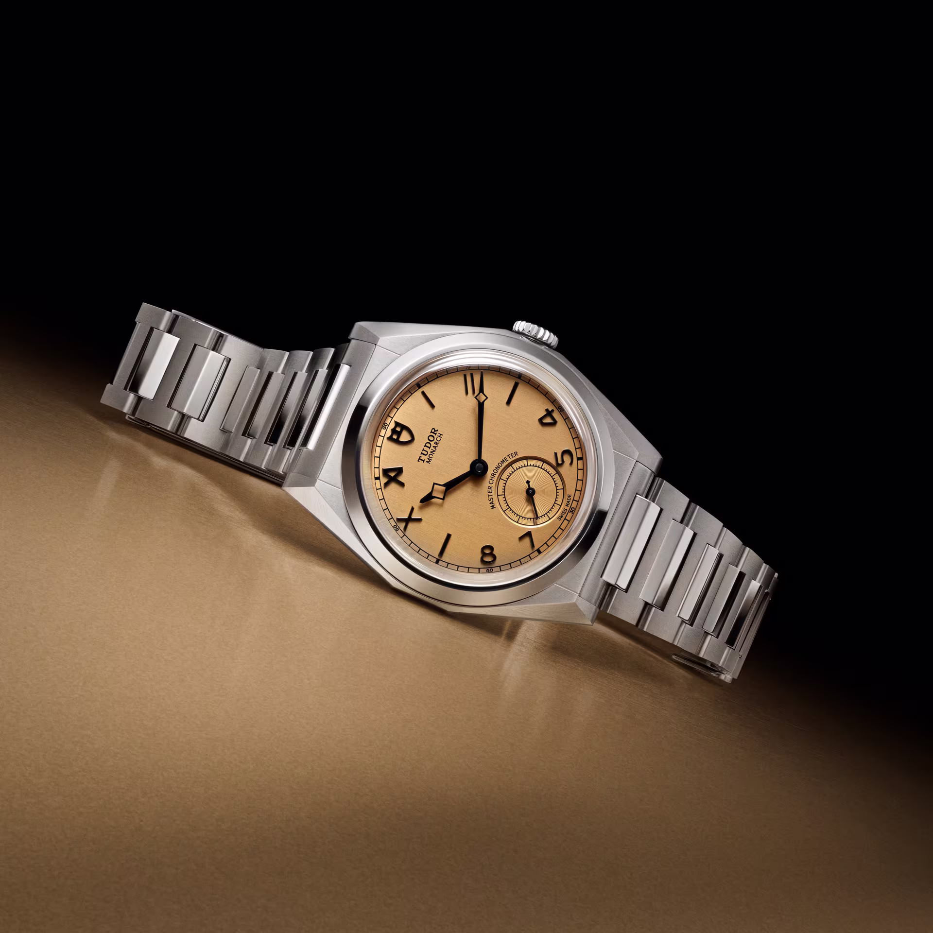 Faceted Tudor Monarch watch on gold surface, centenary edition
