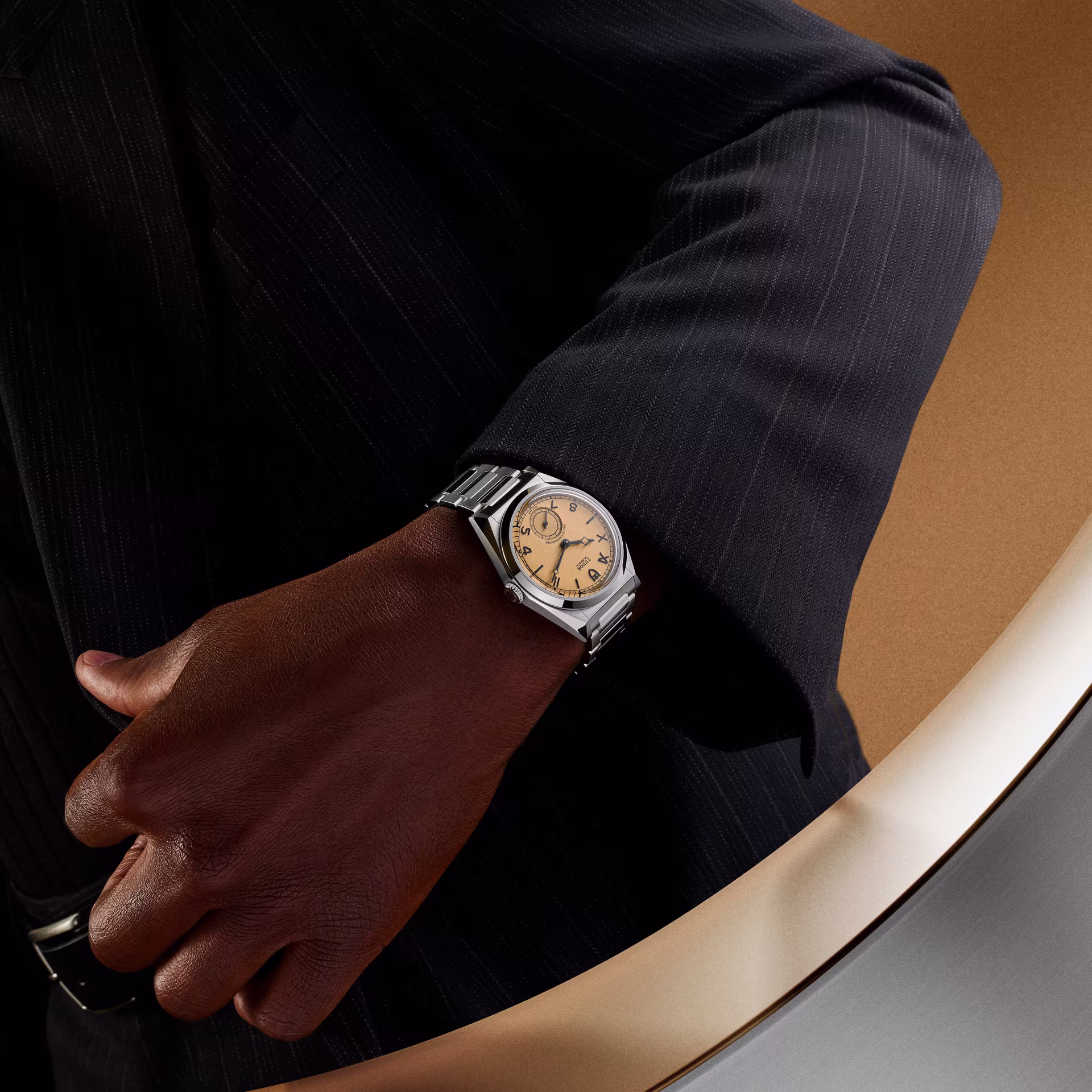 Tudor Monarch worn on dark skin wrist with formal black suit