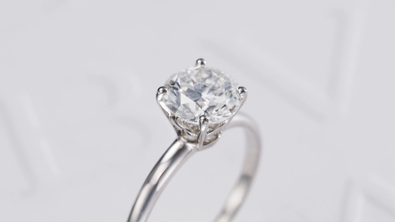 Macro close-up view of the four-prong claw setting and diamond facets of a Bulgari solitaire engagement ring