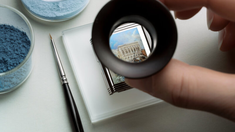 Artisan inspecting a Turner miniature enamel caseback through a loupe
