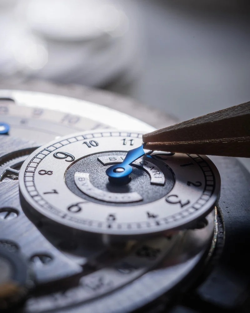Positioning a blue hand over the opaline dial.