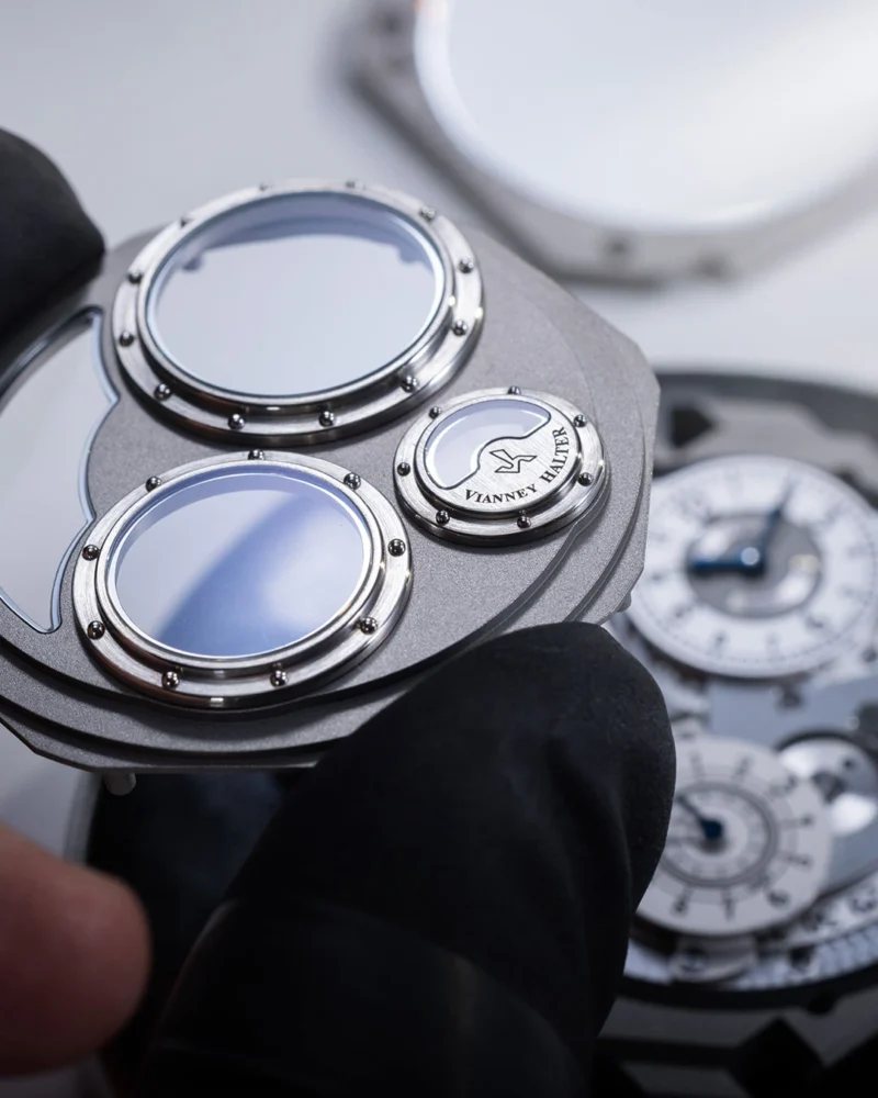 Raised porthole bezels on the titanium case during assembly.