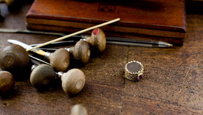 Buccellati workshop bench with goldsmith tools and a jewel setting.