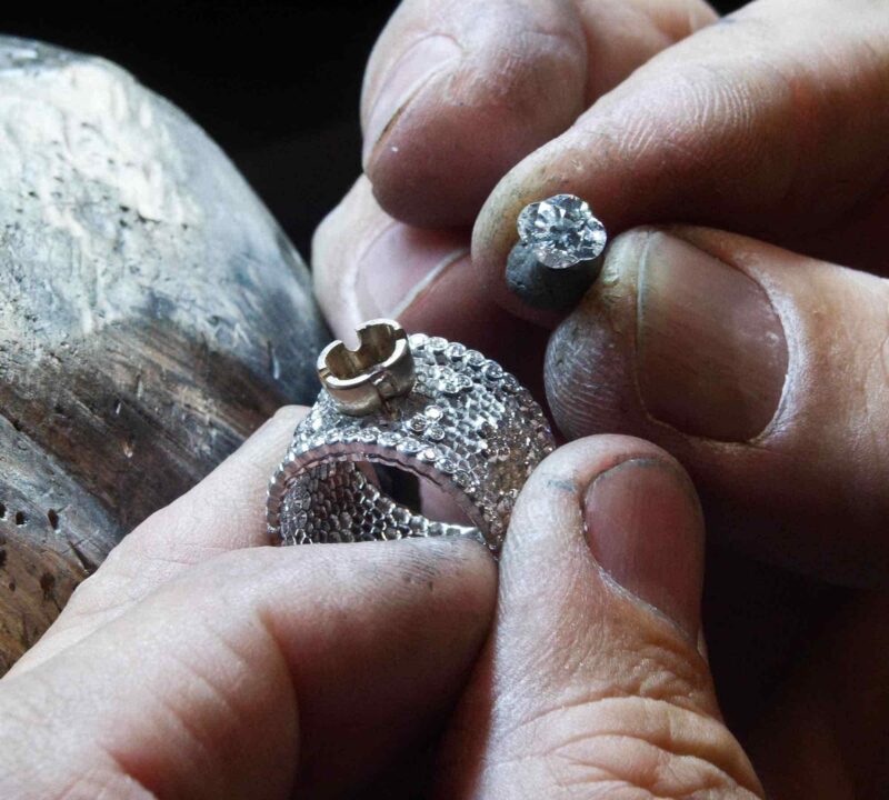 Hands working on a jewel in Buccellati craftsmanship photography.