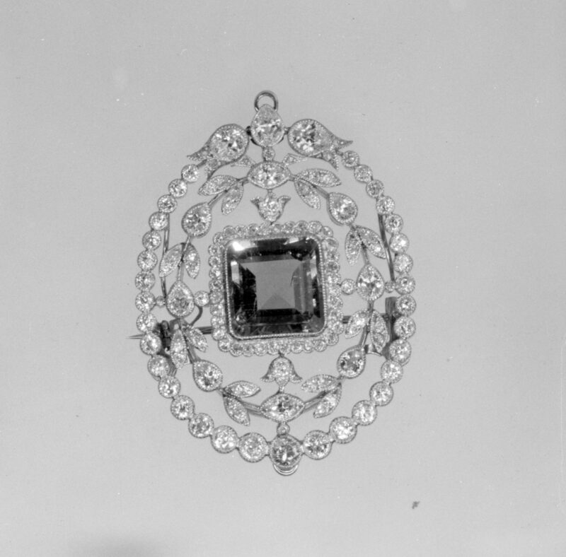 Black-and-white museum photograph of the emerald and diamond brooch.